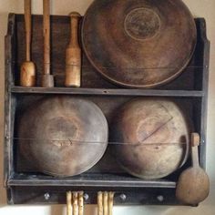 an old wooden shelf with pots and pans on it