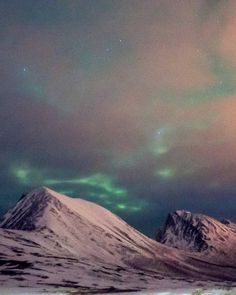 the aurora lights shine brightly in the sky above snow covered mountains