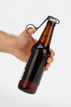 a hand holding a beer bottle with a key in it