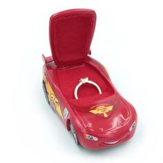 a red toy car with a ring in it