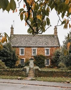 an old brick house surrounded by trees and bushes