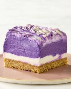 a piece of cake on a plate with purple and white frosting in the middle