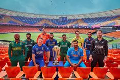 a group of men standing next to each other in front of an empty stadium