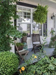 a porch with chairs and plants on it