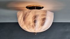 a ceiling light that is hanging from the ceiling in a room with dark walls and flooring