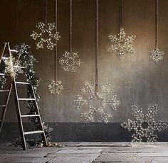 snowflakes are hanging on the wall next to a ladder