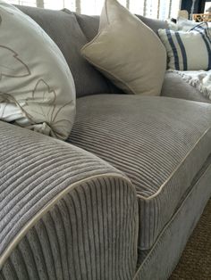 a large gray couch with pillows on top of it