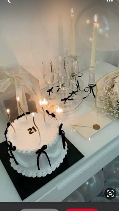 a birthday cake with candles on it sitting on top of a table next to other items