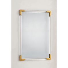 a white and gold framed mirror hanging on the wall