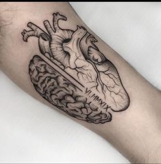 a black and white tattoo of a human heart on the left arm with a brain in it