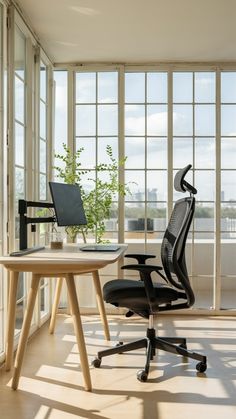 an office chair sitting next to a desk in front of large windows