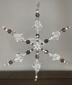 a glass snowflake hanging from a wooden table