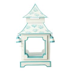 a white and blue birdhouse with trees on the roof, sitting in front of a white background