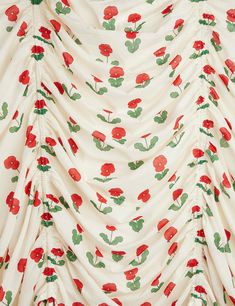 a red and green flowered print on a white background with long ruffles