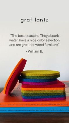 a stack of colorful books sitting on top of a wooden table