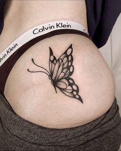 a woman's stomach with a butterfly tattoo on her belly and the words, calvin klein