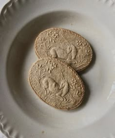 two cookies are sitting on a white plate