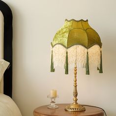 a lamp on a table next to a bed