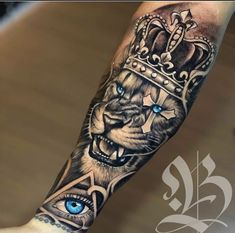 a tiger with a crown on his head and blue eyes is shown in this tattoo