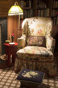 a chair and ottoman in a room with bookshelves