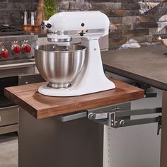 a white mixer sitting on top of a wooden counter