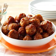 a white bowl filled with meatballs on top of an orange plate