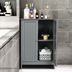 a gray cabinet with soaps, lotion and other items on it in a bathroom