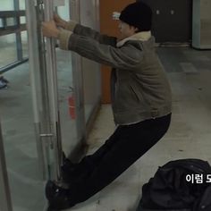 a young man leaning against a glass door