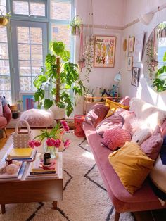 a living room filled with lots of furniture and plants on top of the couches