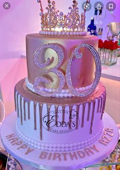 a 30th birthday cake decorated with pink icing and gold crown on the top tier