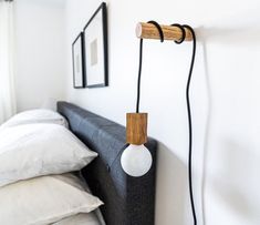 a bed with a wooden headboard and two lights hanging from it's sides