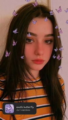 a girl with butterflies on her head and long brown hair is looking at the camera