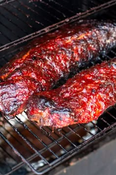 two pieces of meat cooking on a grill