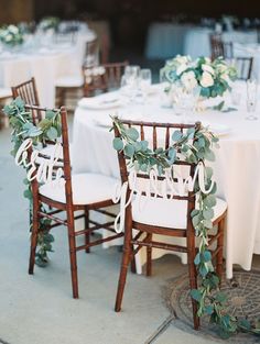 the wedding table is decorated with white flowers and greenery