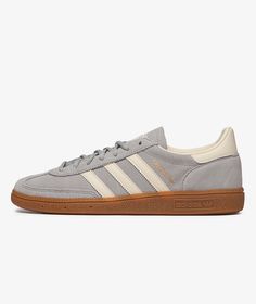 a grey and white adidas sneakers with gum soles