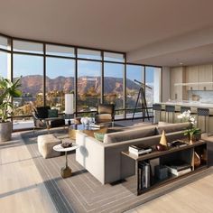 a living room filled with lots of furniture and large windows overlooking the mountain range in the distance