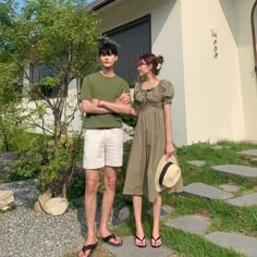 a man and woman standing in front of a house