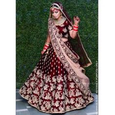 a woman in a red and gold bridal gown with her hand on her hip