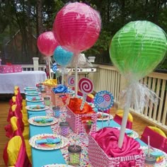 a long table is set up with paper lanterns and candy bar wrappers for an outdoor birthday party