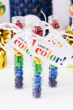 some candy sticks with colorful candies in them and a sign that says love in color