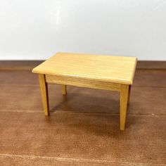 a small wooden table sitting on top of a hard wood floor