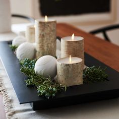 some candles are sitting on a black tray