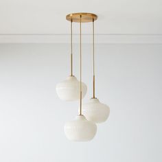 three white globe lights hanging from a ceiling