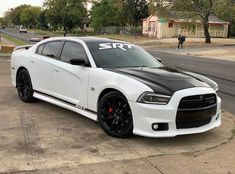 a white and black car is parked on the street