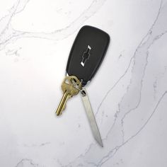 a car key and a pair of scissors on a marble surface