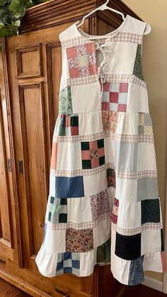 a white dress hanging on a wooden cabinet