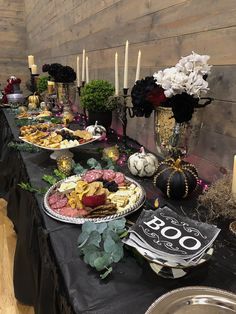 the table is set up with many plates and silverware on it, along with candles