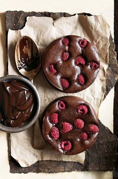 three chocolate cakes with raspberries on top