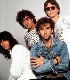 an image of four men posing for the camera with their arms around each other and one man wearing sunglasses