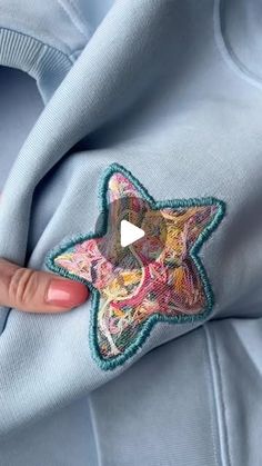 someone is holding onto a blue sweatshirt with a star on it